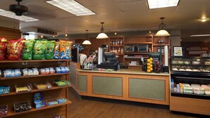 A snack and deli counter with various packaged snacks, a cash register, and a refrigerated display case. - 2 BR/2 BA with Kitchen at Hilton HGVC (Las Vegas)