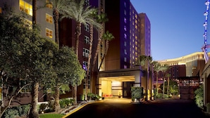 A hotel entrance with palm trees and a well-lit facade. - 2 BR/2 BA with Kitchen at Hilton HGVC (Las Vegas)