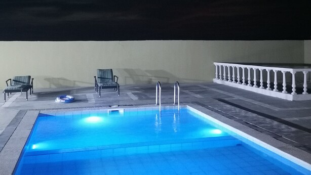 Una piscina con dos sillas y una barandilla blanca.