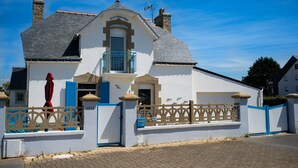 A white building with a blue door and a balcony. - Exceptional seafront location (Étel)