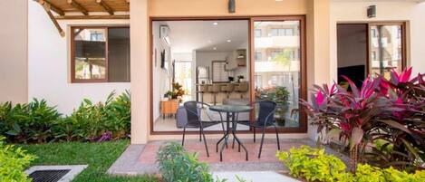 Eine moderne Außenpatio mit Essbereich, umgeben von üppigem Grün und einem gepflegten Garten.