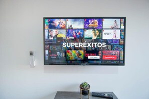 Ein an der Wand befestigter Fernseher zeigt verschiedene Filmtitel und Fernsehsendungen an.