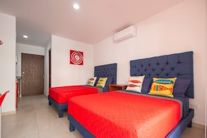 Ein Hotelzimmer mit zwei Betten, einer roten und blauen Farbgestaltung und einer Wanddekoration, die an ein Ziel erinnert.