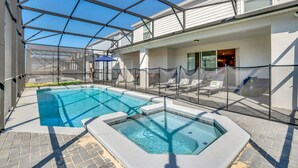 Een zwembadgedeelte met een glazen structuur, ligbedden en een jacuzzi.