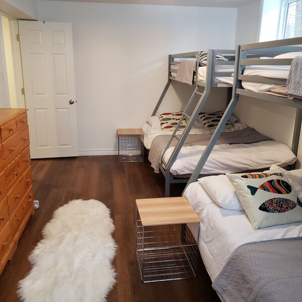 Una habitación con literas, un aparador de madera y una alfombra de piel.