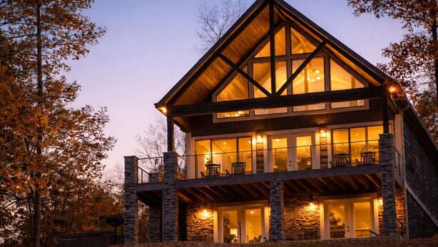 A multi-story log cabin with large windows and stone pillars.