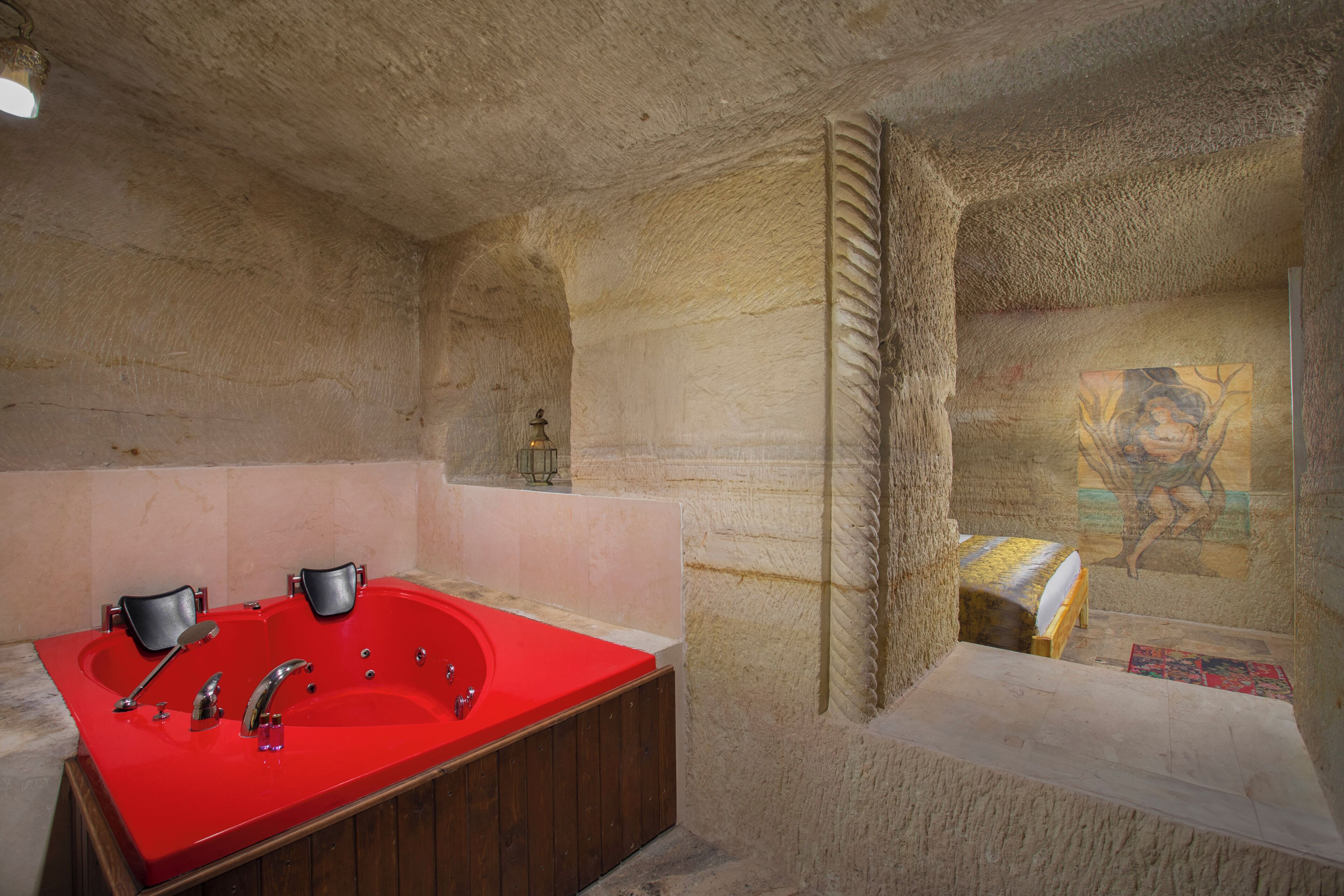Un baño con un lavamanos rojo, dos lavabos y una bañera de madera.