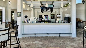 A restaurant with a white counter, hanging lights, and a menu board. - WATERPARK! Mickey & Superhero! EPIC Resort Close 2 Disney! 2730 (Kissimmee)