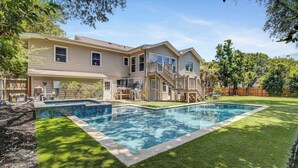 A two-story house with a swimming pool, a covered patio, and a wooden deck. - 11 43rd Avenue by Avantstay Pool + Close to Beach! (Isle of Palms)
