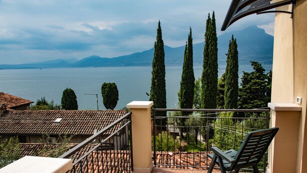A terrace with a view of a lake and mountains.