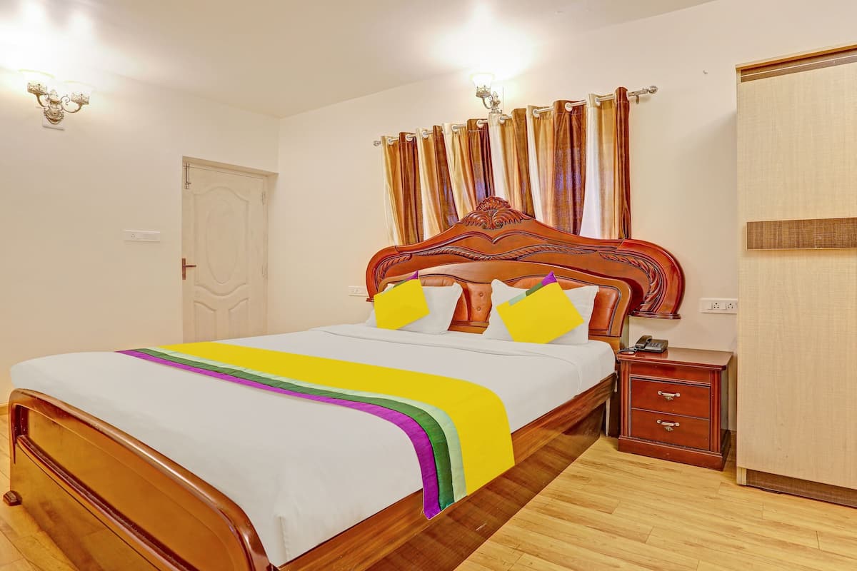 Un dormitorio ordenado con una cama de madera, una mesita de noche, un armario y una puerta.