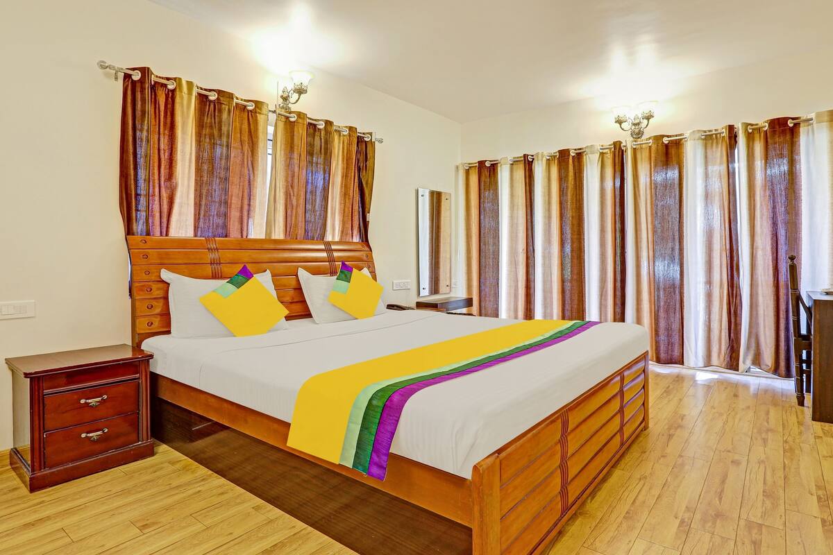 Un dormitorio ordenado con una cama de madera, una mesita de noche y un aparador de madera.