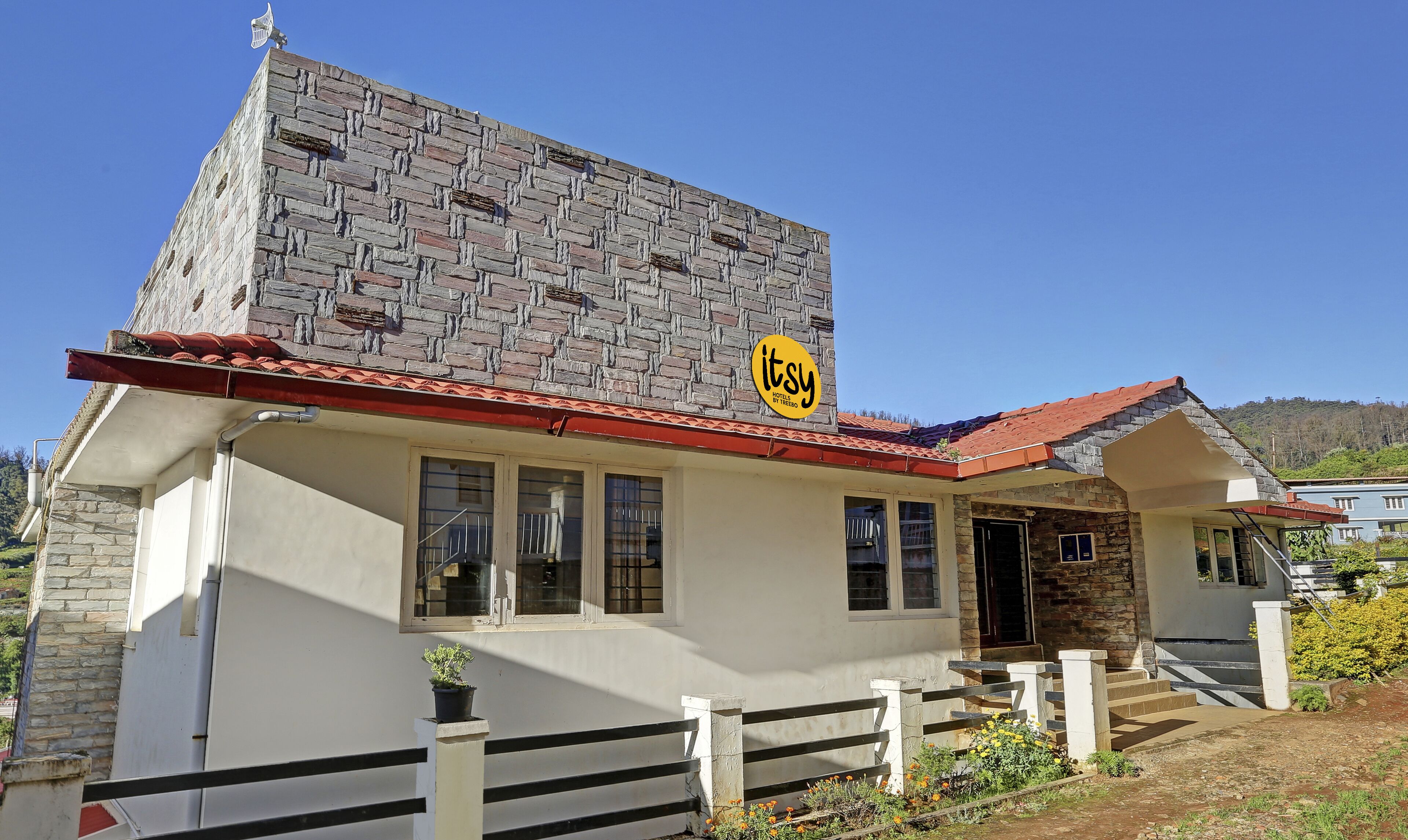 A hotel with a stone facade, a red-tiled roof, and a sign indicating it's a TRESPO hotel.
