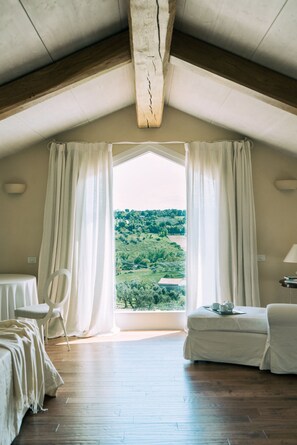 A room with a wooden ceiling, a large window with curtains, a bed, a chair, and a table with a tray. - Exclusive villa rental in Nontiscordar with a pool in the Marche region (Civitanova Marche)