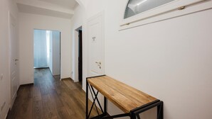 A hallway with a wooden bench, white walls, and a door with a 'DO NOT ENTER' sign.