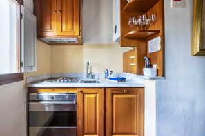 A kitchen with wooden cabinets, a stainless steel oven, a sink, and a wine glass rack. - Piazza Santa Croce - Two Bedroom Apartment, Sleeps 4 (Firenze)
