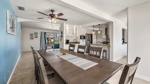 A modern kitchen with white cabinets, a built-in oven, and a stainless steel refrigerator.