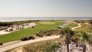 A golf course with a view of the ocean, featuring sand bunkers, water hazards, and a well-maintained green. - 45 Ocean Point by Avantstay Amazing Views + Beach Access & Community Pool Access (Isle of Palms)