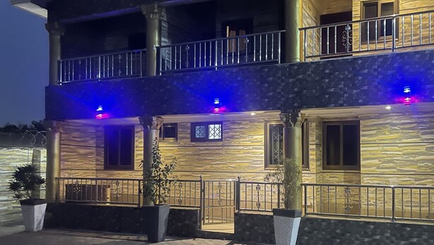 A two-story building with a balcony, stone facade, and potted plants. - LOYALTY HOTEL  (Accra)