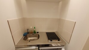 A compact kitchen with a stainless steel sink, a built-in stove, and a refrigerator.