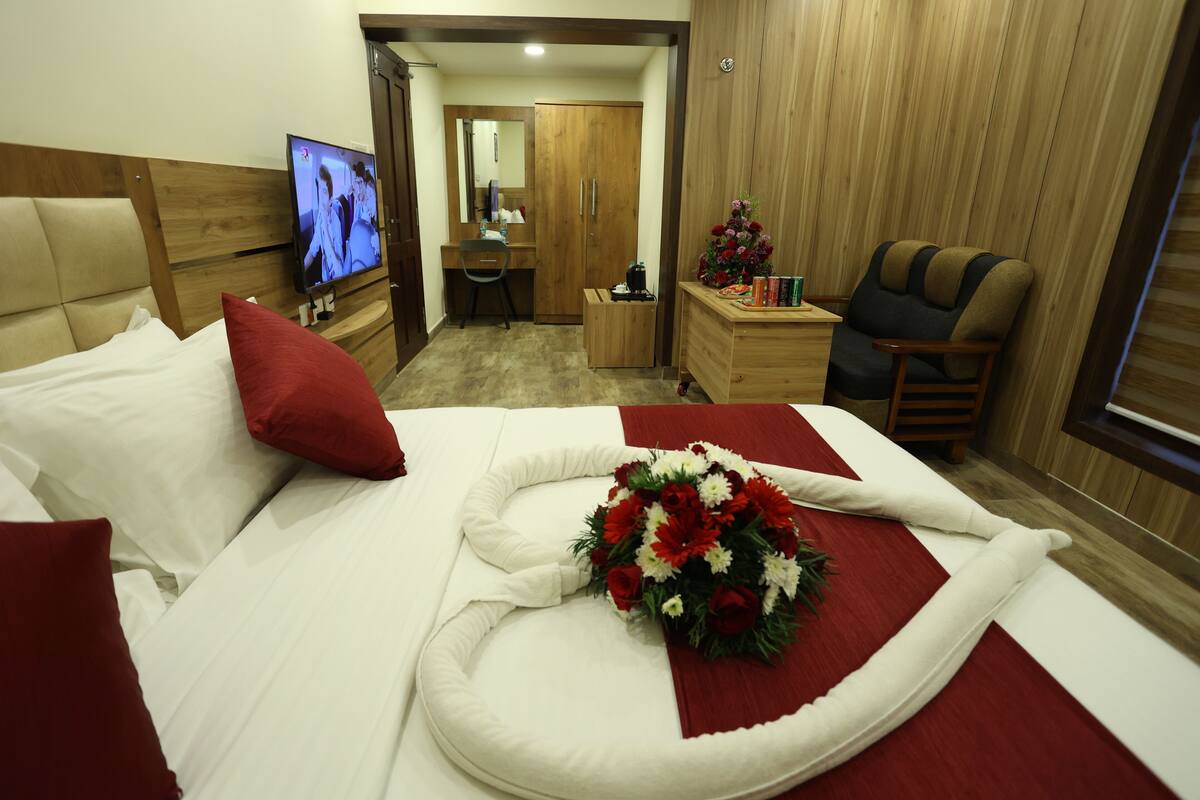 Ein Hotelzimmer mit Bett, Fernseher, Schreibtisch und Kleiderschrank.