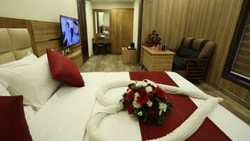 Una habitación de hotel con cama, televisión, escritorio y armario.