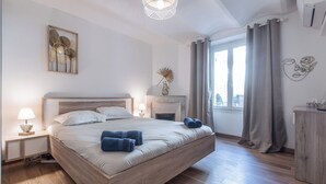 Una camera da letto con un letto grande, un comodino, una lampada, un camino e vista sull'esterno.