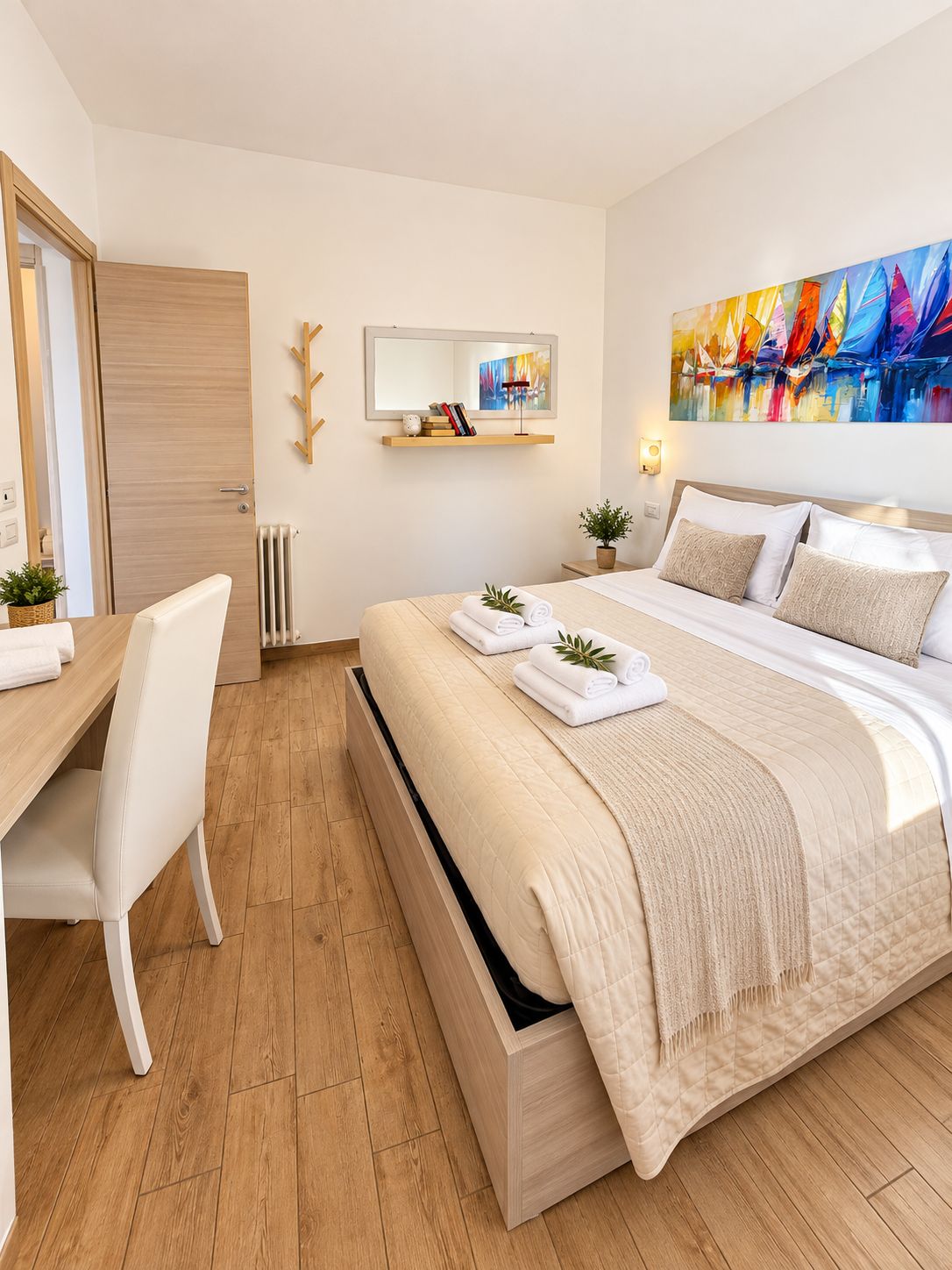 A modern hotel room with a bed, a desk, and a chair.
