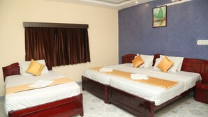A hotel room with two beds, a large window with curtains, a wall-mounted painting, and a patterned floor. -  LA FLORA RESORTS YERCAUD (Yercaud)