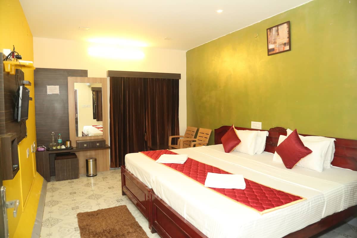 A hotel room with a large bed, a wooden dresser, a mirror, a desk, and a trash can.