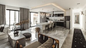 A spacious living area with a large window, a dining area, and a kitchen with modern appliances. - Black House Aldea Zama (Tulum)