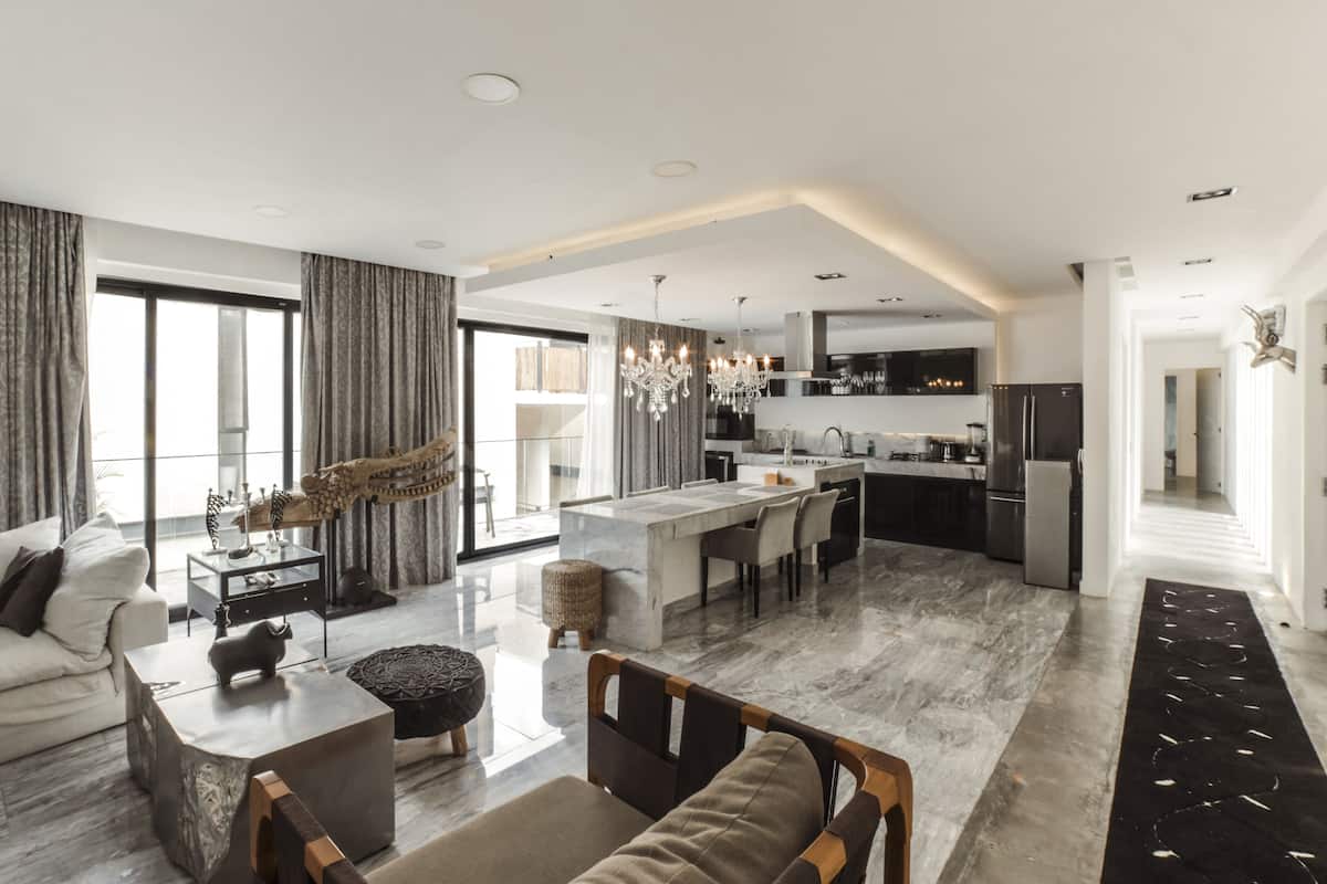 A spacious living area with a large window, a dining area, and a kitchen with modern appliances.