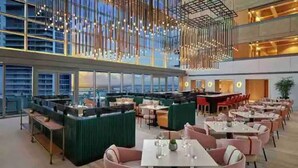 A modern restaurant with high ceilings, hanging light fixtures, and a view of the cityscape. - Luxury Brickell Bay View Condo AKA Hotel 33rd Floor (Miami)
