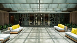 A modern lobby with a glass entrance, two sofas with yellow cushions, and a patterned floor. - Luxury Brickell Bay View Condo AKA Hotel 33rd Floor (Miami)