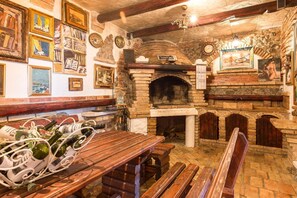 Cozy space with a brick fireplace, wooden benches, and framed artworks.