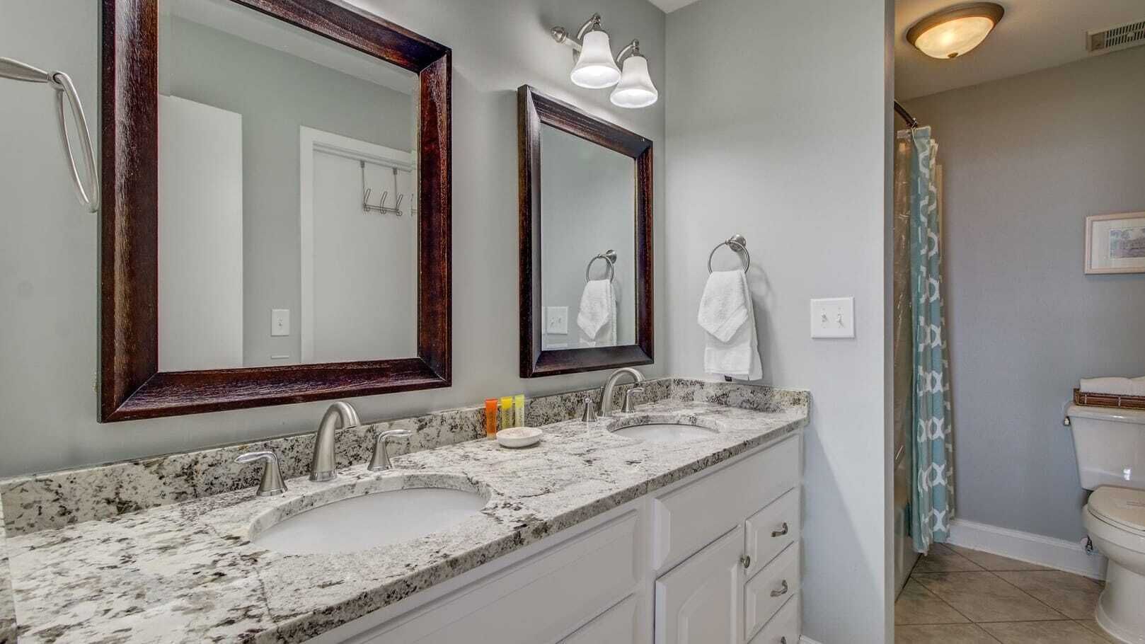 A bathroom with two sinks, a mirror, and a shower curtain.