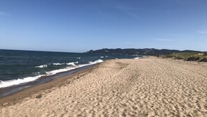 Une vaste plage de sable fin, avec des vagues douces et un ciel dégagé.