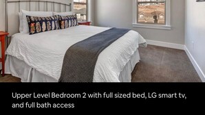 Ein Schlafzimmer im Obergeschoss, Nummer 2, mit einem Doppelbett, einem LG Smart-TV und eigenem Badezimmer.