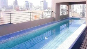 A rooftop swimming pool with a city view, surrounded by a metal railing. - Cozy Studio 7 Palermo Soho/ Balcony/Pool/Sum/AA. (Buenos Aires)