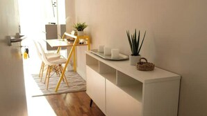A modern kitchen with a white countertop, wooden chairs, and a yellow chair. - Cozy Studio 7 Palermo Soho/ Balcony/Pool/Sum/AA. (Buenos Aires)