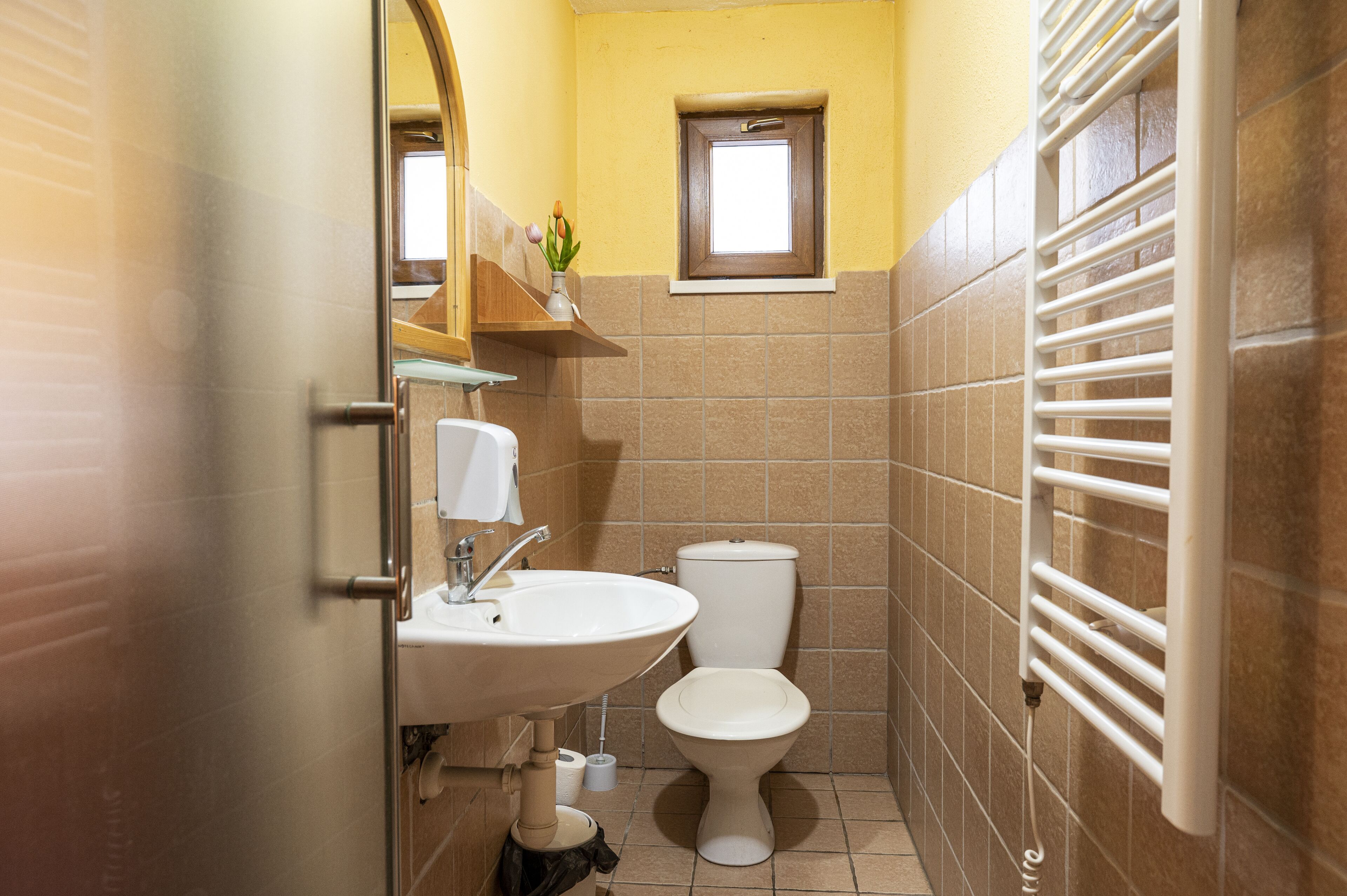 A small bathroom with a toilet, sink, and towel rack.