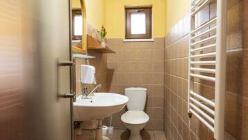 A small bathroom with a toilet, sink, and towel rack.