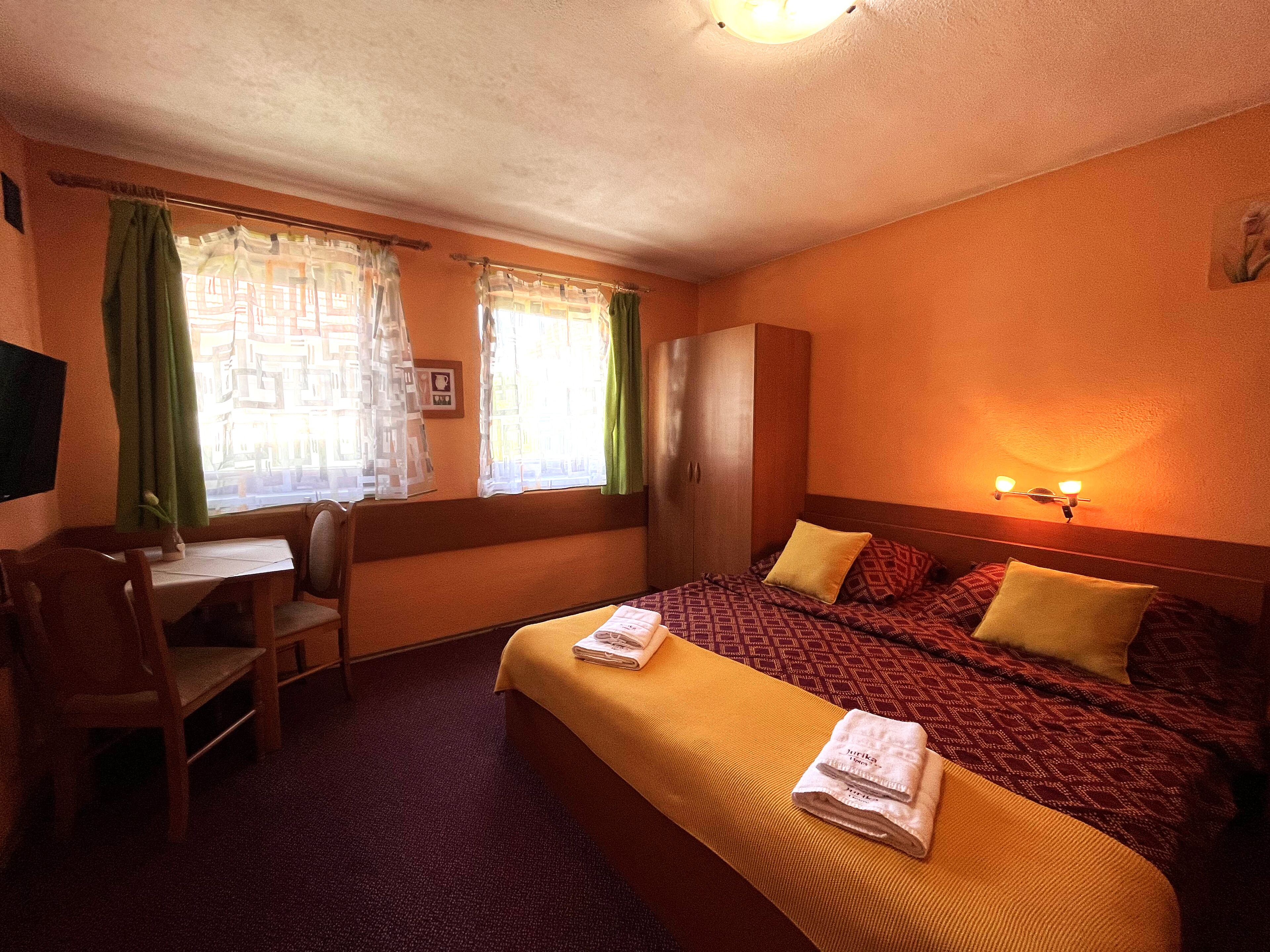 A hotel room with a bed, a desk, and a chair.