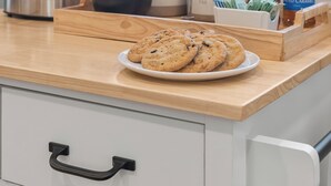 Eine Küchenarbeitsplatte mit einer Kaffeemaschine, einem Teller Kekse und Torani-Sirup.