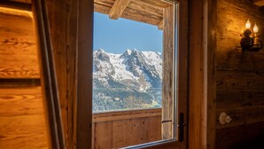 Une porte en bois avec une fenêtre donnant sur un paysage de montagne enneigé.