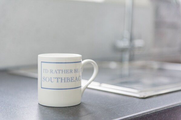 A white mug with blue text on a kitchen counter.