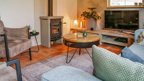 A cozy living room with a fireplace, a television, and comfortable seating.