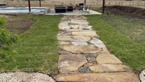 A stone pathway leading to a covered area with a pool and outdoor furniture. - Cabernet Cabin (Seguin)