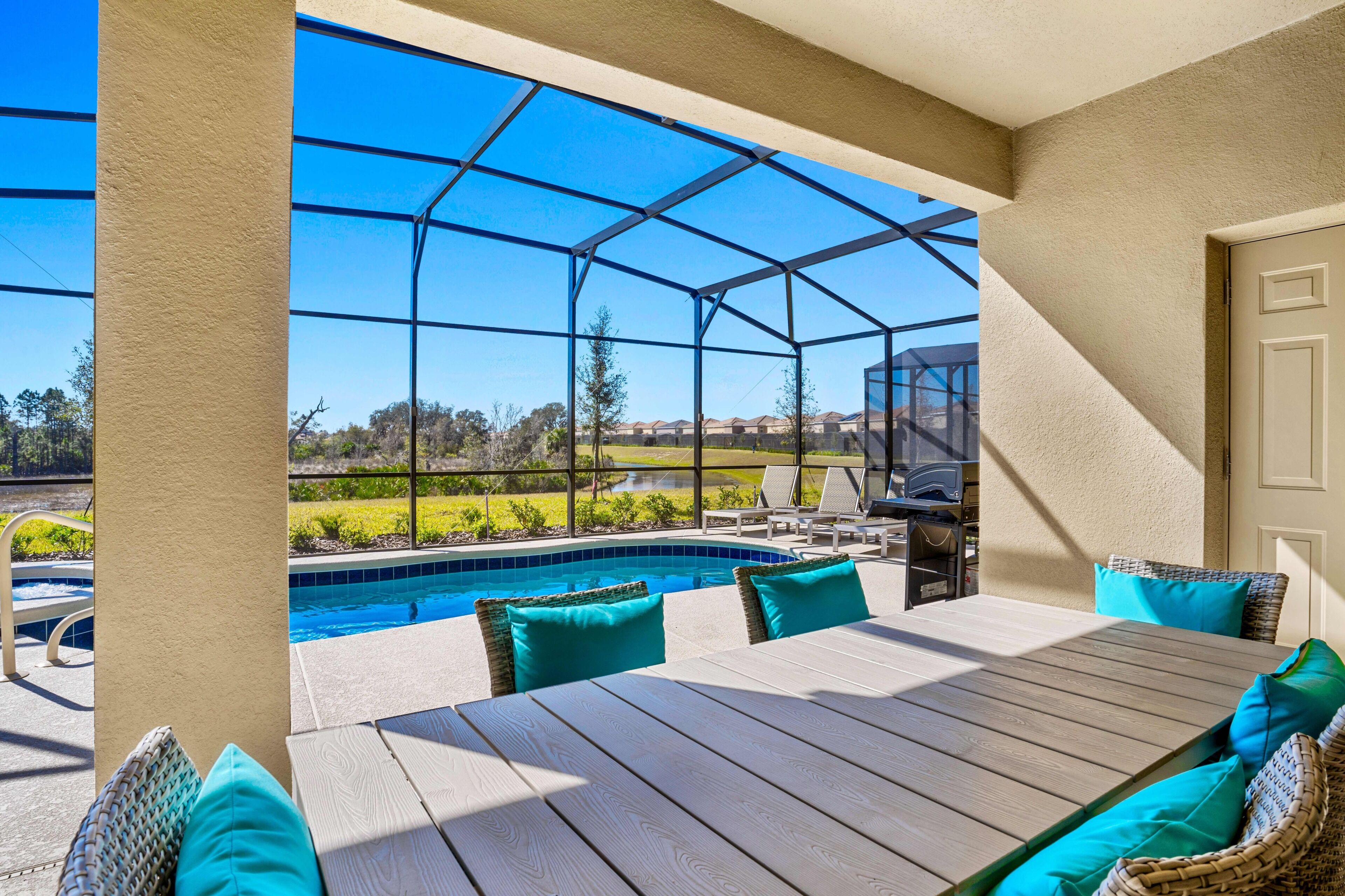 Un patio techado con piscina, mobiliario exterior y vistas del paisaje circundante.