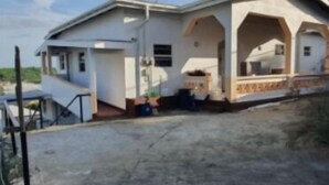 Una casa de dos pisos con un porche cubierto y un garaje.